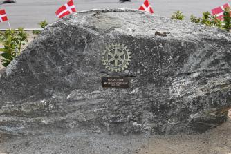 På stenen er et Rotaryhjul og en plade med forklaring.